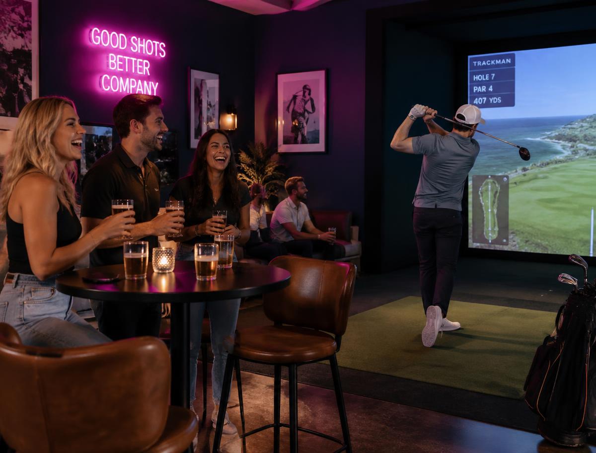 Friends enjoying the Chez Putters golf simulator